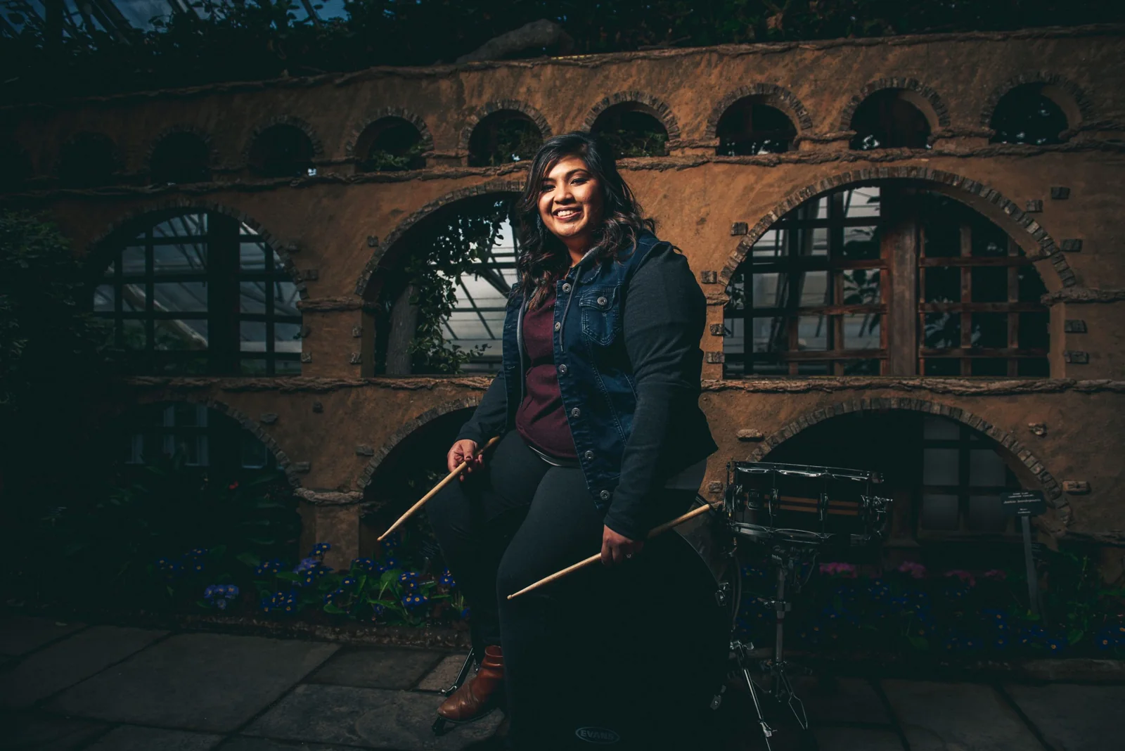 Sharon Ransom with drumsticks under stone arches
