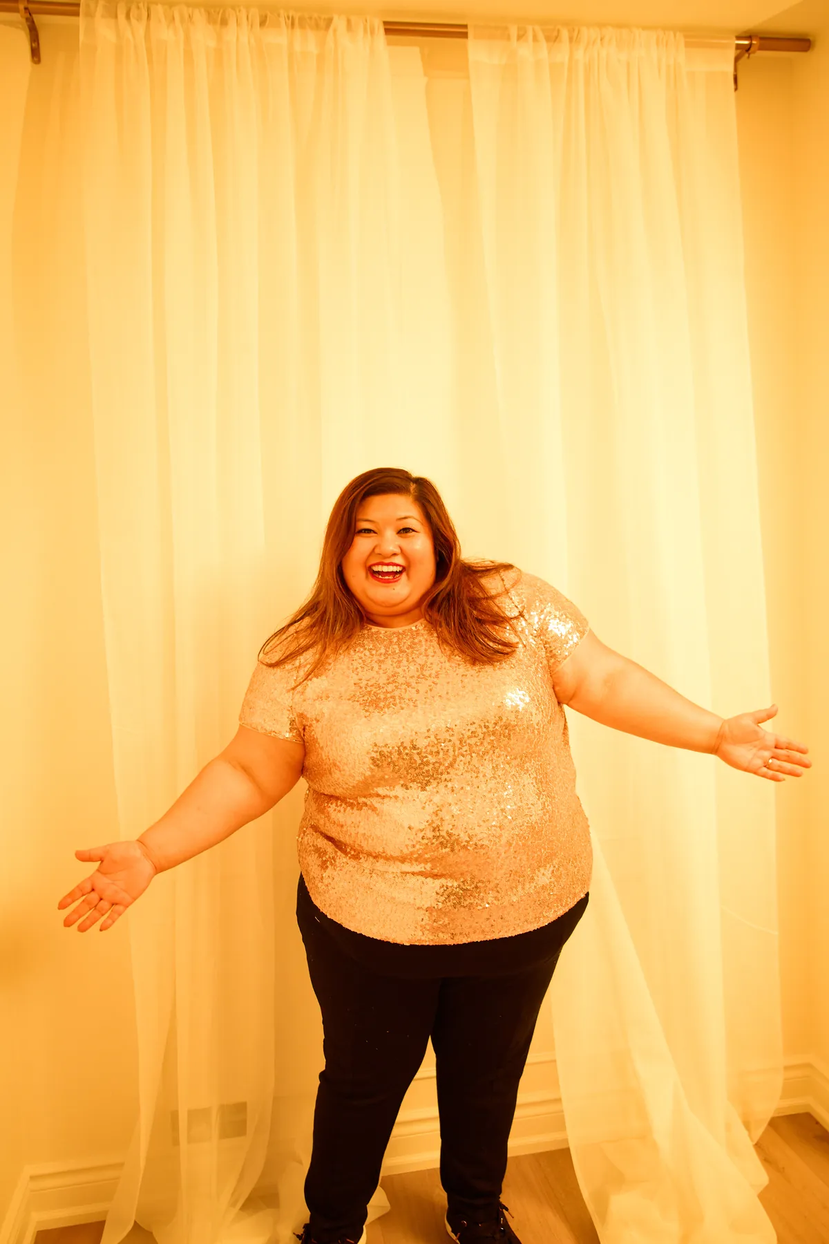 Sharon Ransom smiling with arms open in her studio